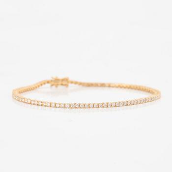 A tennis bracelet in 14K gold with round brilliant-cut diamonds.