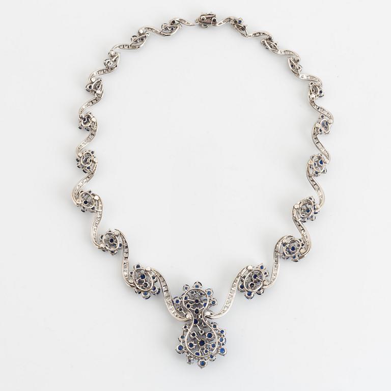 An 18K white gold necklace set with round brilliant-cut diamonds and sapphires.