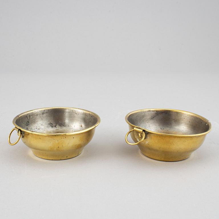 A pair of brass candelabra for two candles "Blekingestakar and a pair of brass cups, 1800/1900.