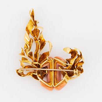 A Kutchinsky brooch in 18K gold set with coral and round brilliant-cut diamonds.
