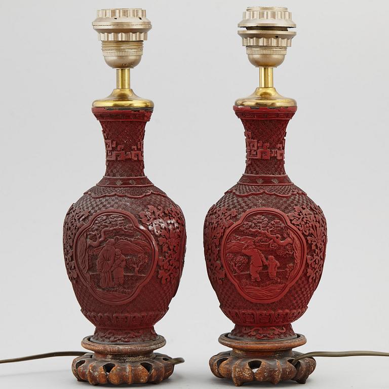 A pair of Chinese red lacquered vases, turned into table lamps, 20th century.