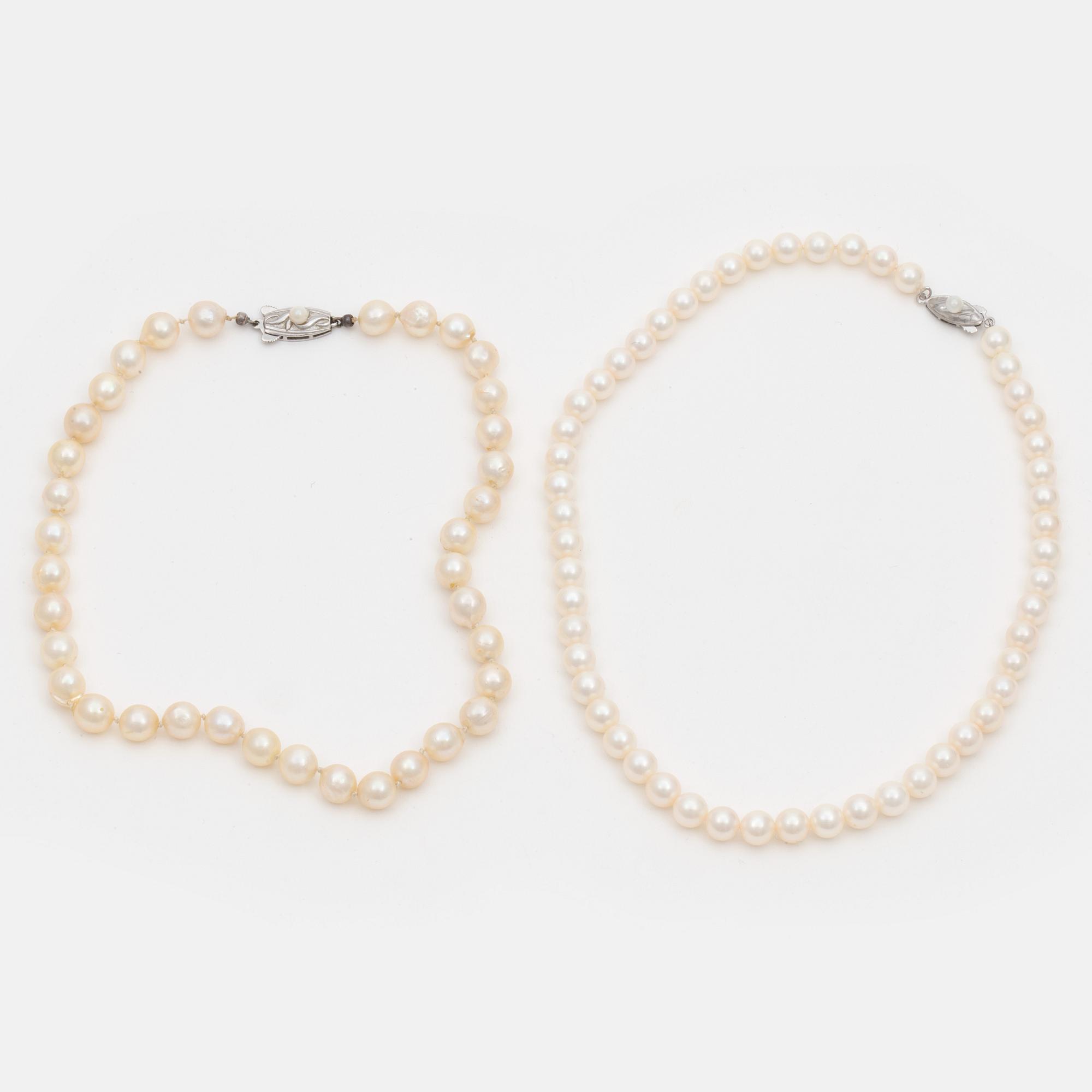 Two cultured pearl necklaces with silver clasps.