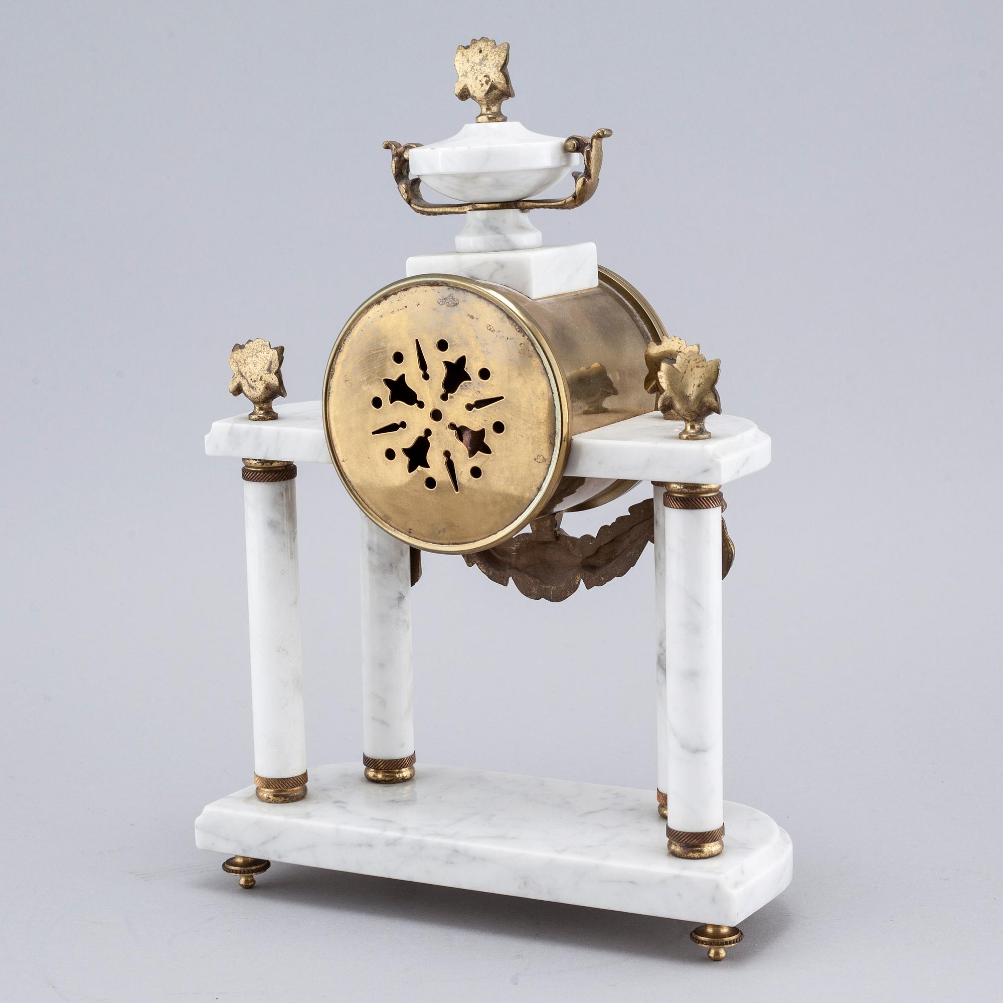 A French mantlepiece clock and a pair of candelabras, first half of the 20th century.