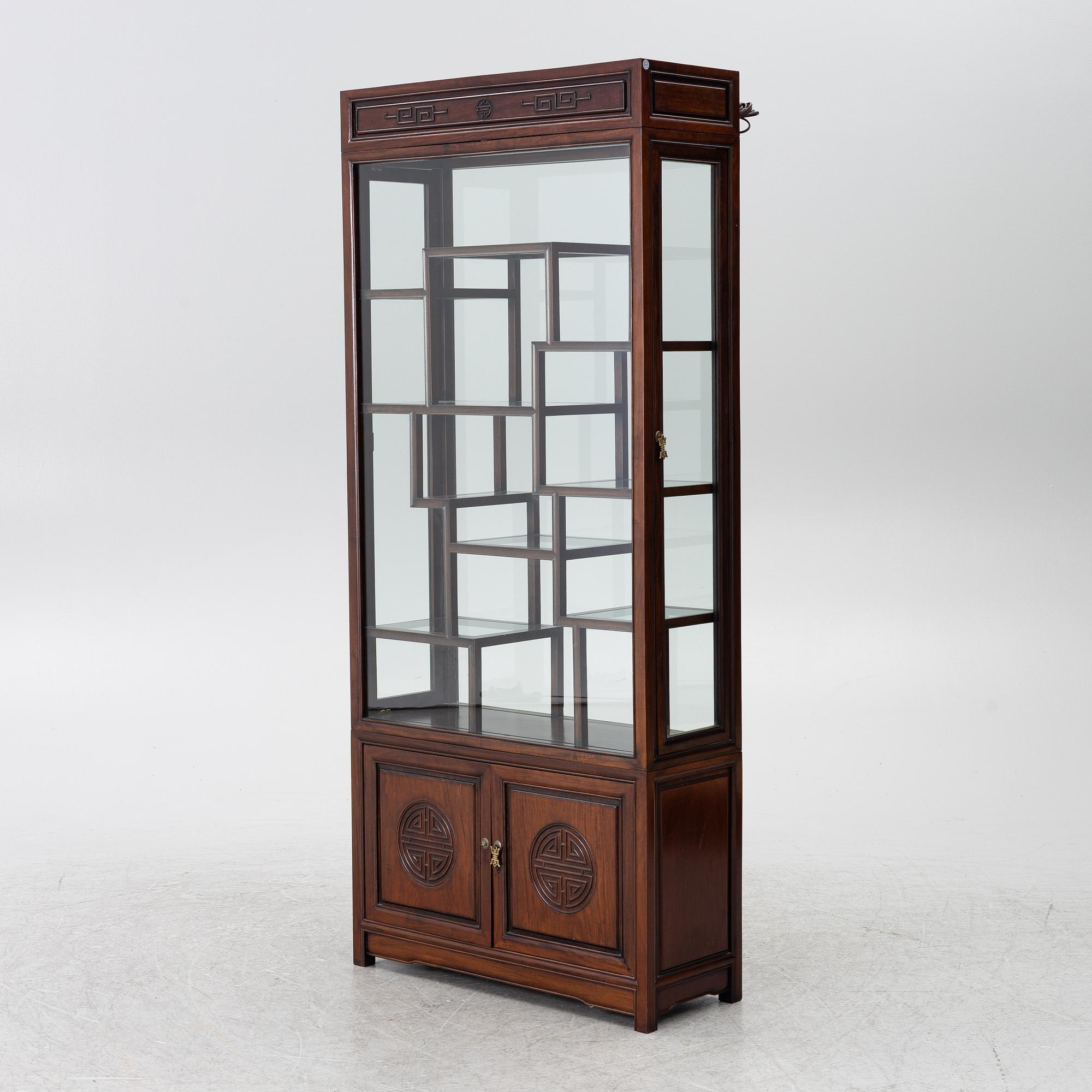 A Chinese display cabinet, wood and glass, later part of the 20th century.
