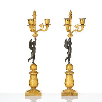 A pair of Empire three light ormolu and patinated bronze candelabra.