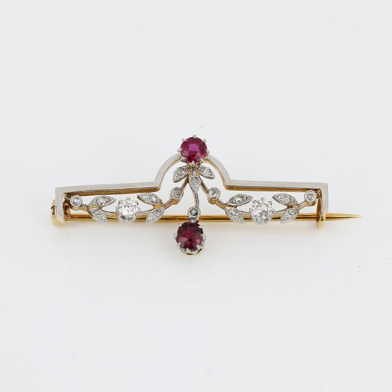 BROSCH, 18K guld med runda fasetterade rubiner, tot ca 0,40 ct och små rosen och gammalslipade diamanter. Vikt ca4,48 g.