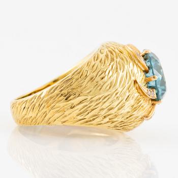 A ring in 18K gold with a blue faceted zircon and eight-cut diamonds.