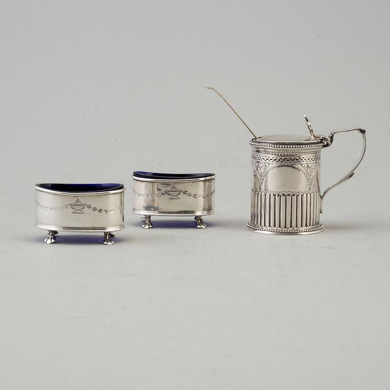 A silver mustard can and a pair of salt cellars. british. Dated 1879 resp. 1911.