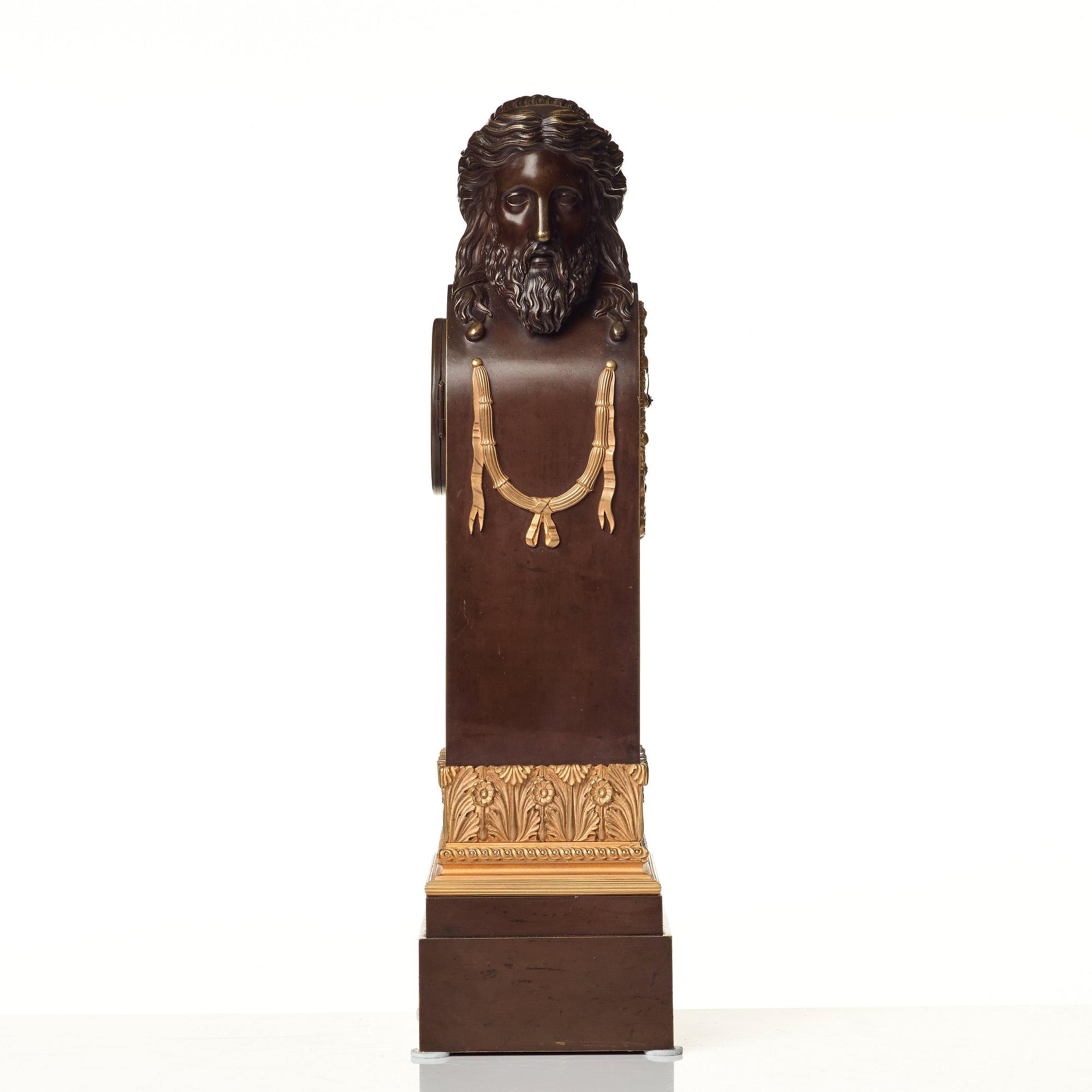 An Empire early 19th century gilt and patinated bronze mantel clock.