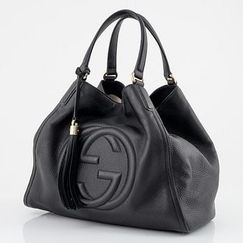 Gucci, a black leather handbag.