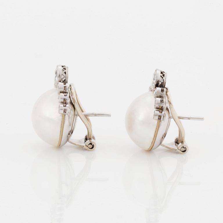 A pair of 18K white gold earrings set with mabe pearls and round brilliant-cut diamonds.