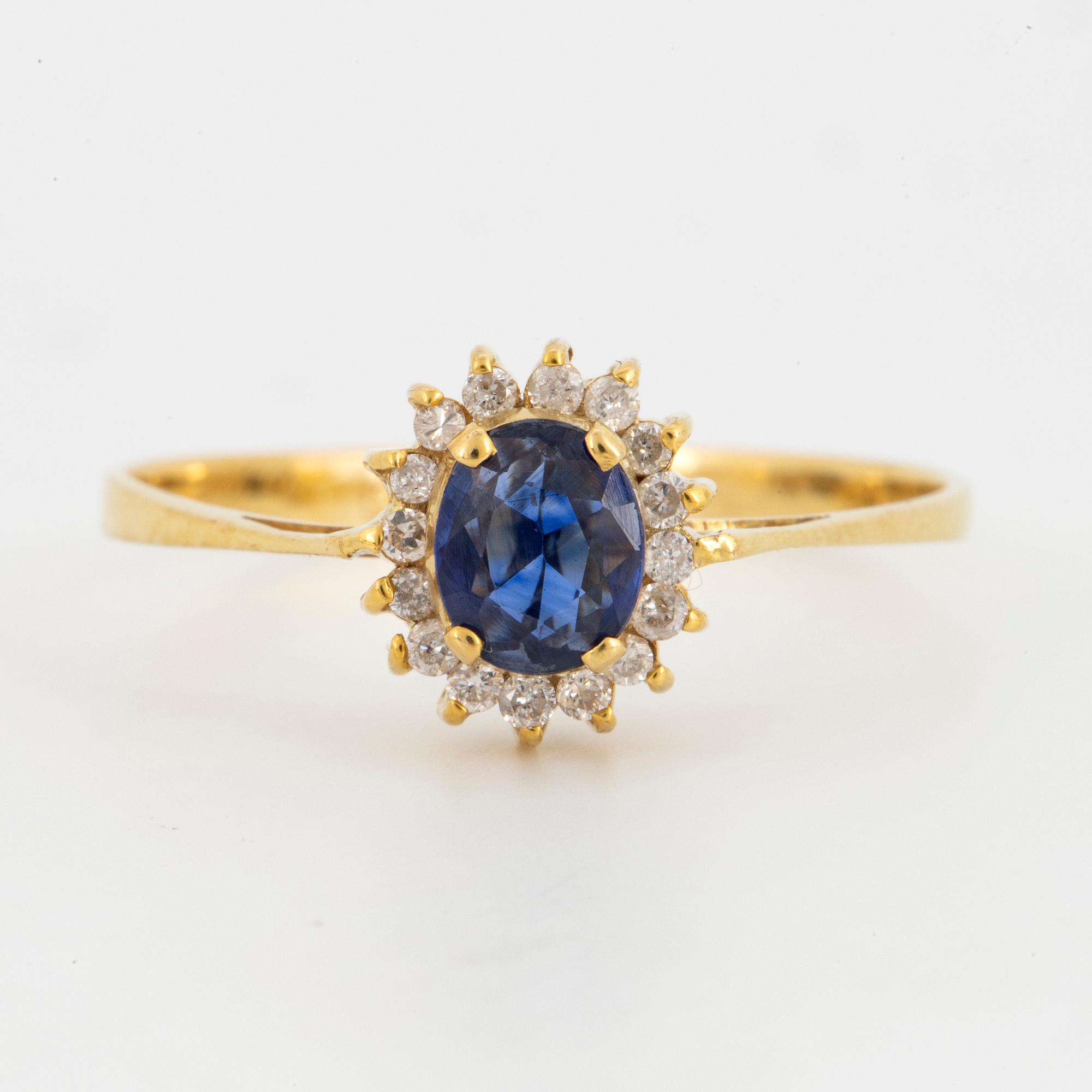 Oval mixed-cut sapphire and round brilliant-cut diamond halo ring.