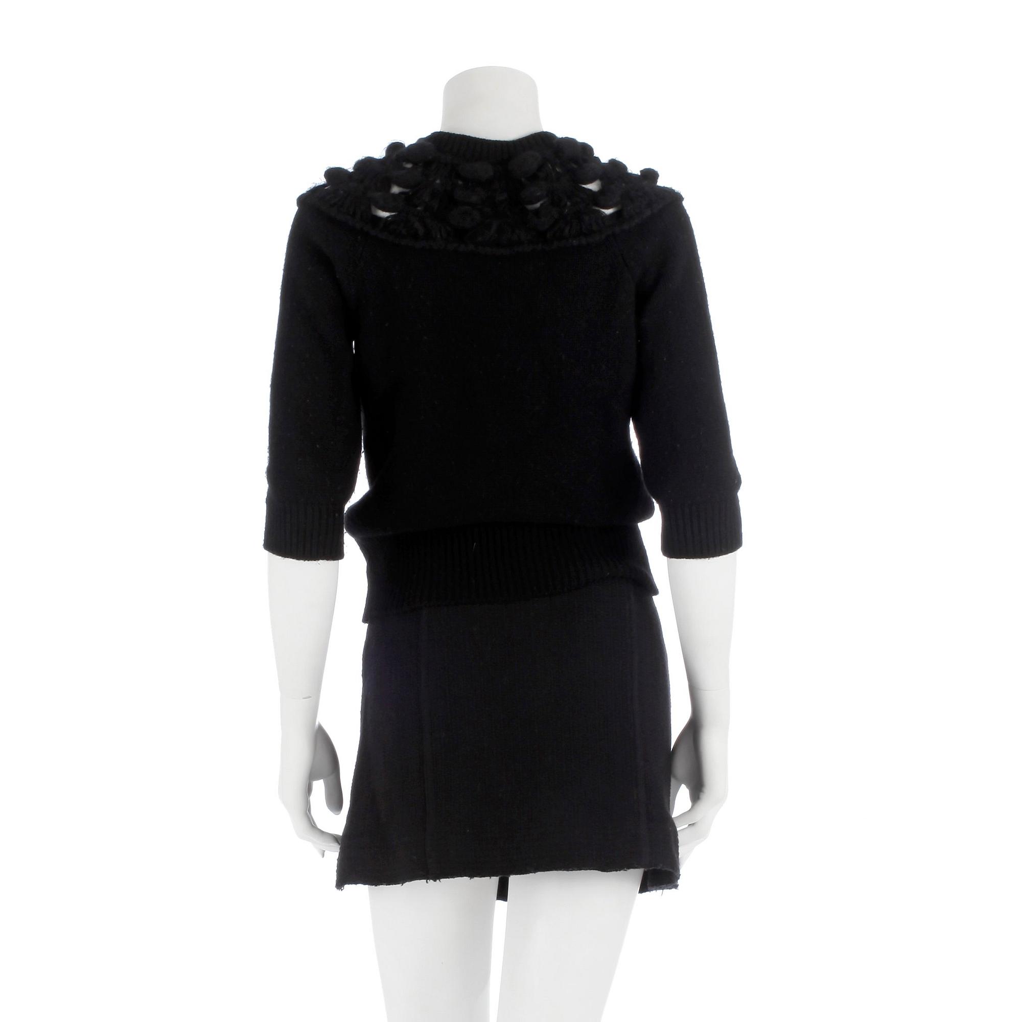 CHANEL, a black cashmere carding and a bouclé skirt.