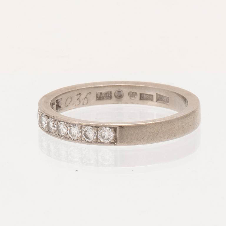 An 18K white gold half eternity ring set with round brilliant-cut diamonds.