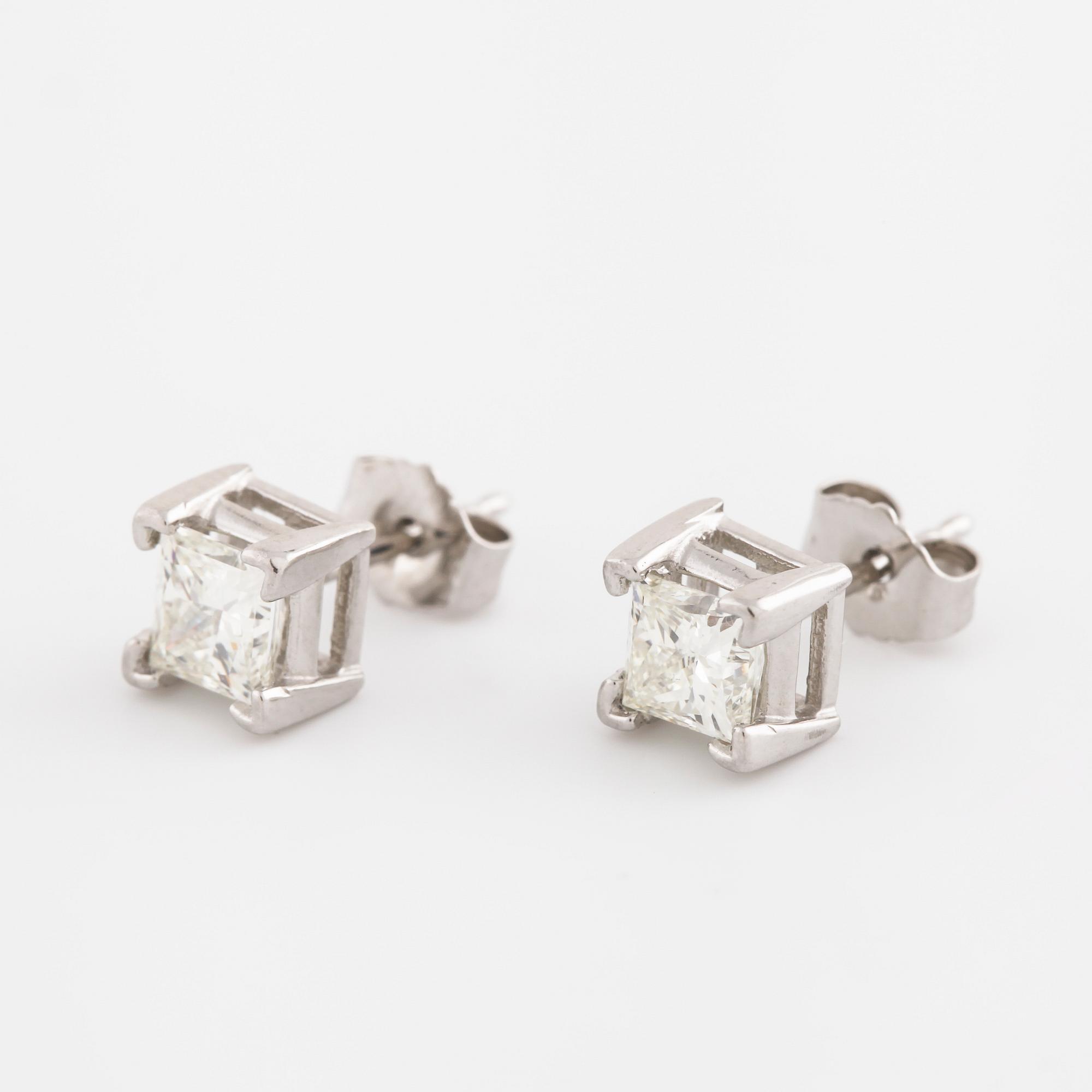 A pair of princess cut diamond earrings.