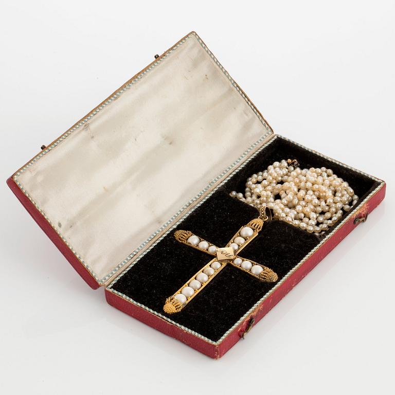 A pearl cross pendant and two pearl necklaces.