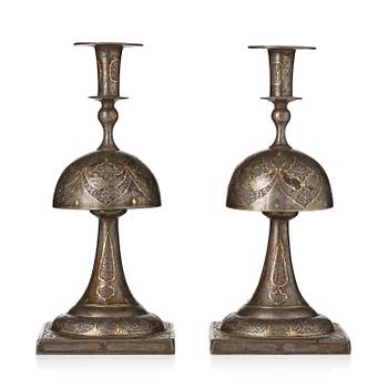 373. A pair of Persian gold-damascened steel candlesticks, Qajar dynasty, 19th century.