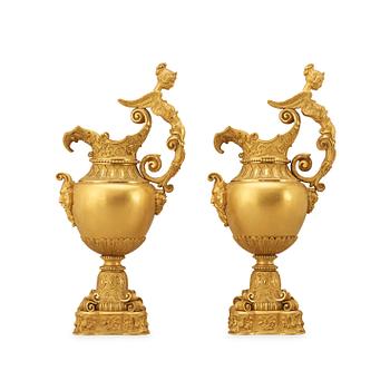 1688. A pair of mid 19th century gilt bronze ornamental ewers.