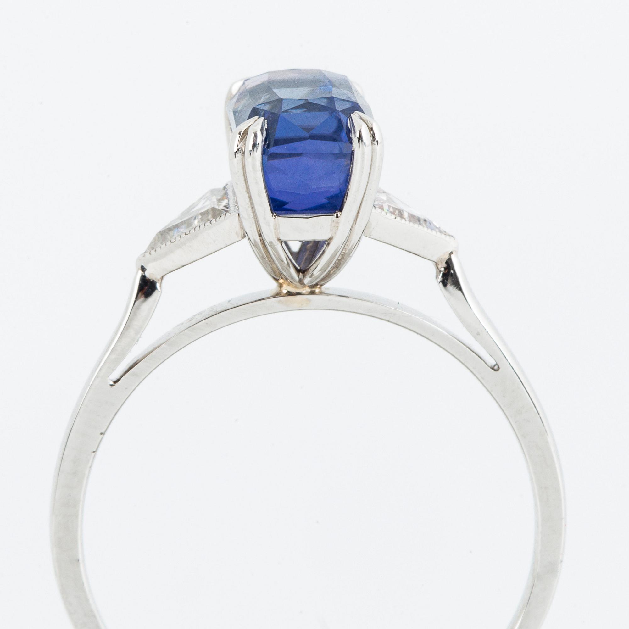 RING, platina, med fasettslipad violettblå safir och triangelslipade diamanter, medföljande certifikat.
