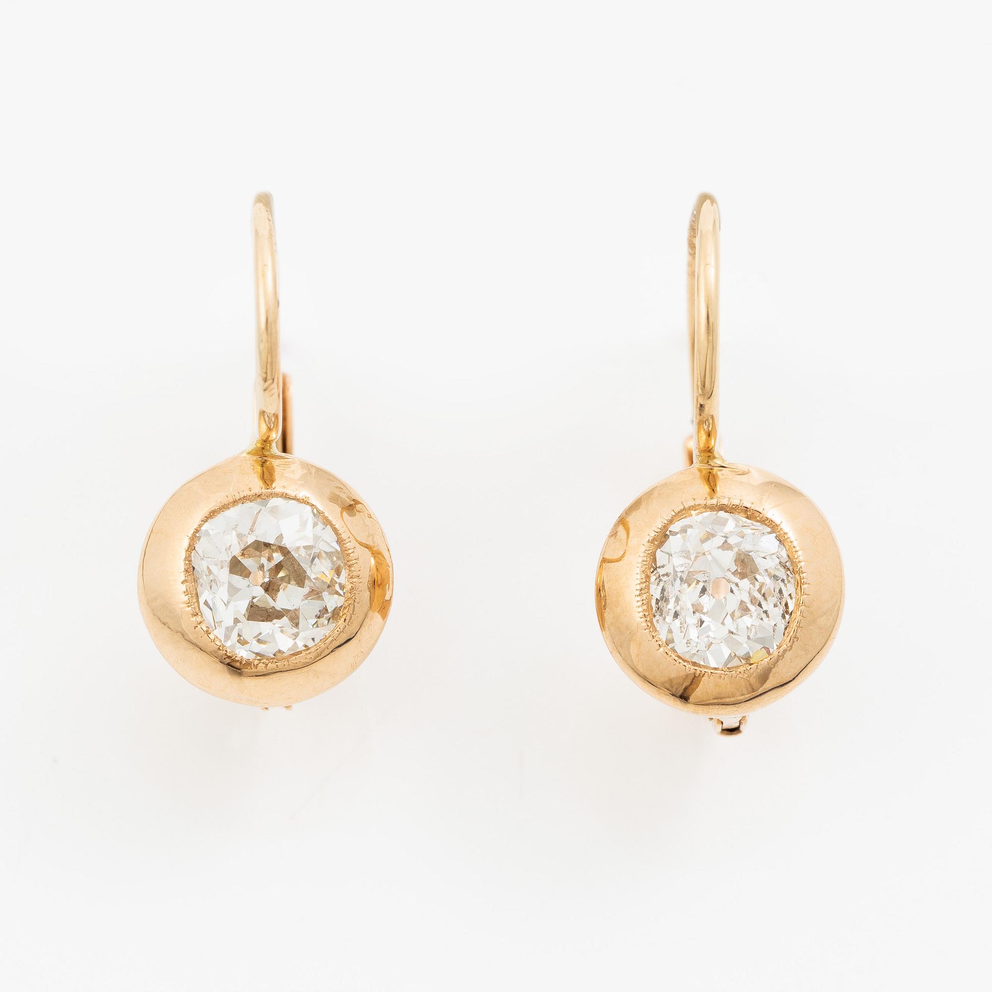 A pair of earrings in 18K gold set with two old-cut diamonds.