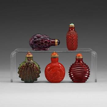 A group of five Chinese snuff bottles with stoppers.