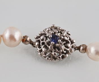 COLLIER. odlade pärlor med lås i silver med fasettslipad blå safir, utländsk stämpel. Vikt 40,5 gram.