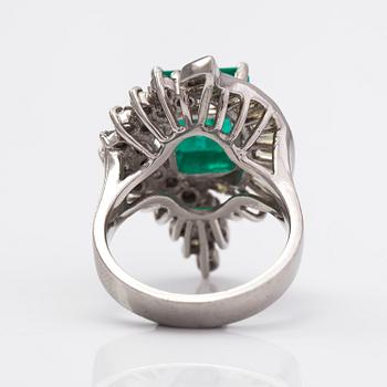 A platinum ring with a ca. 3.20 ct emerald and diamonds ca. 1.16 ct in total.