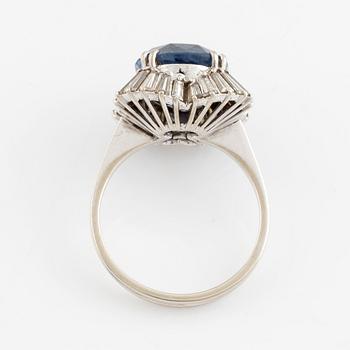 An 18K gold ring set with a faceted sapphire and tapered baguette-cut diamonds.