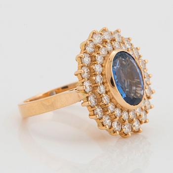 An 18K gold ring set with a faceted sapphire ca 3.50 cts and round brilliant-cut diamonds.