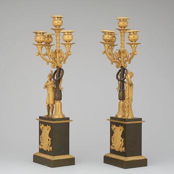 A pair of French Empire early 19th century gilt and patinated bronze four-light candelabra.