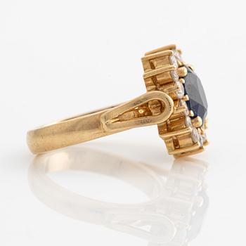 Ring in 18K gold with a faceted sapphire and round brilliant-cut diamonds.