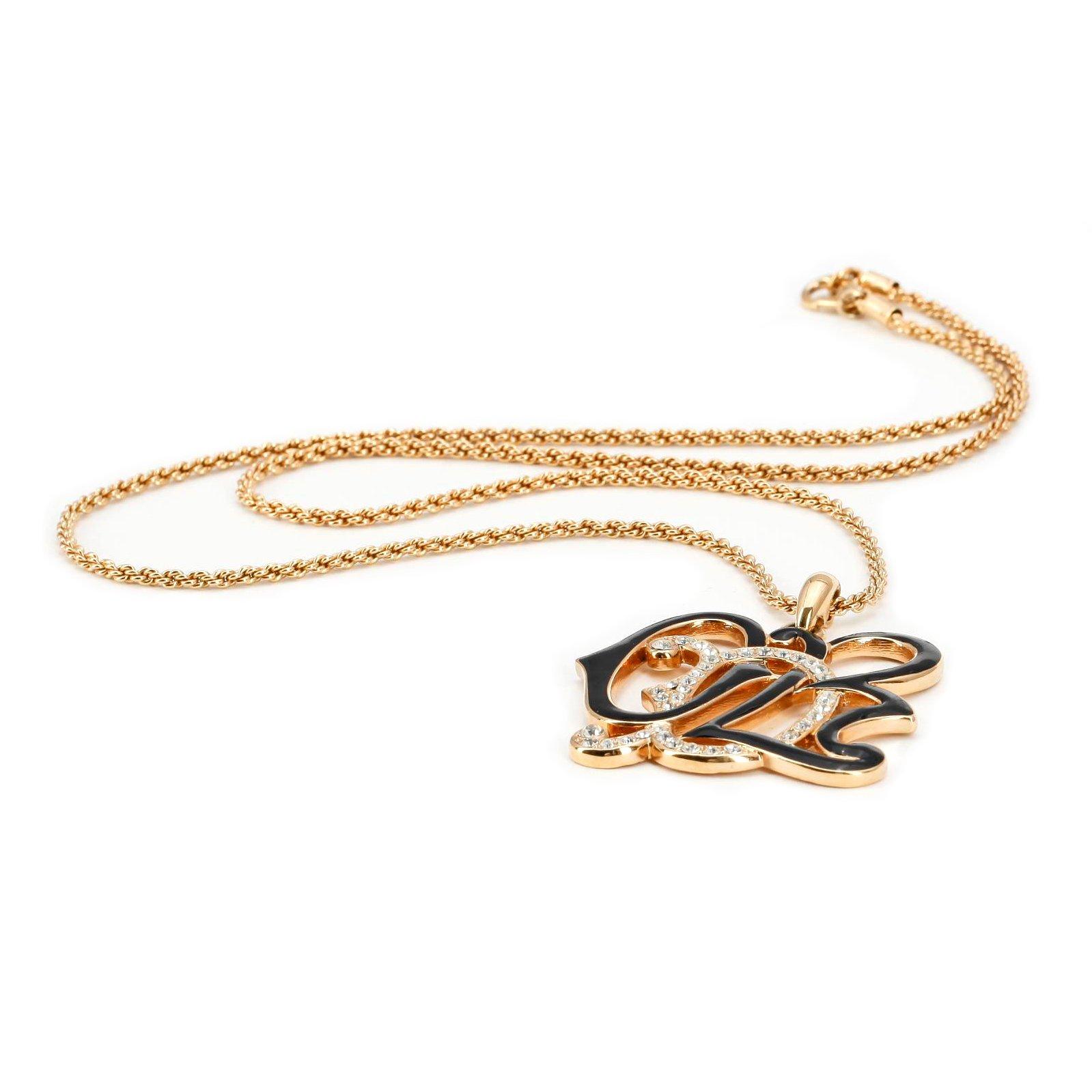 OSCAR DE LA RENTA, a gold colored necklace with pendant.
