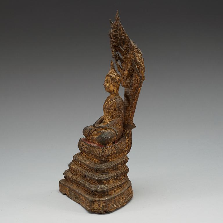 A gilt bronze figure of Buddha, enthroned on a seven headed coiled Naga, Thailand, 19th Century.
