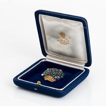 An 18K gold Carlman brooch set with sapphires, emeralds, rubies and pearls.