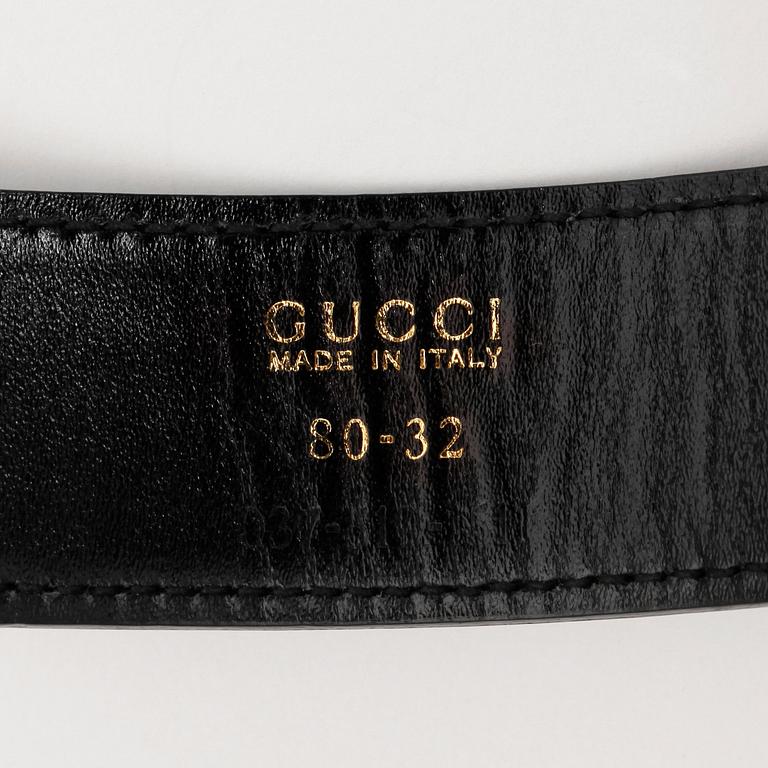 GUCCI, a black patent leather belt.