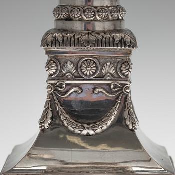 KYNTTELIKKÖPARI, hopeaa. Saksa, vuosisadan vaihde 18/1900. Korkeus 47 cm. Kokonaispaino täytteineen 4085 g.