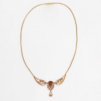 An 18K gold filigree necklace with seed pearls and a citrine, Stockholm 1910.