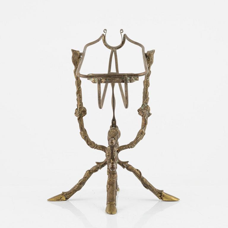 A brass bottle holder, circa 1900.