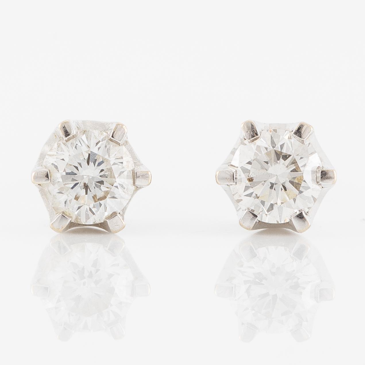 A pair of earrings in 18K gold set with round brilliant-cut diamonds.
