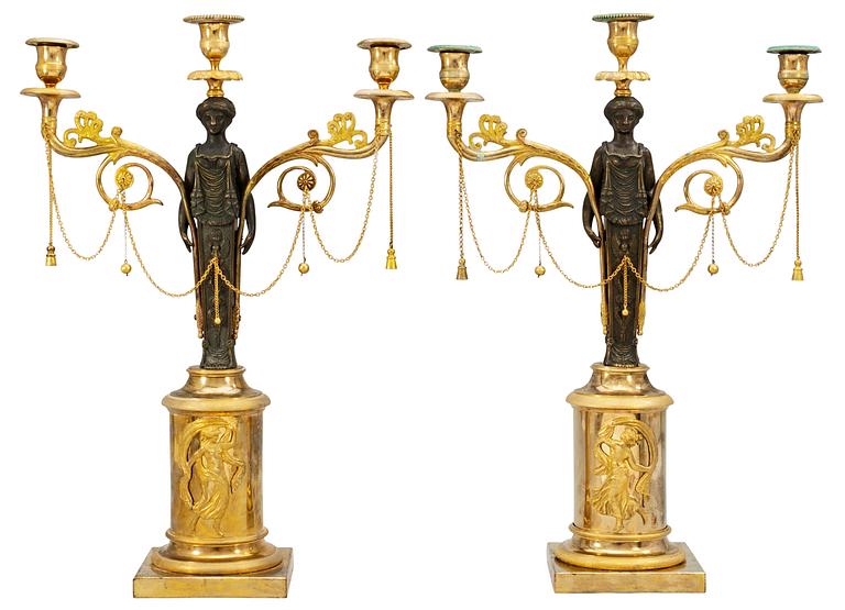 A pair of late Gustavian early 19th century gilt and patinated bronze three-light candelabra.