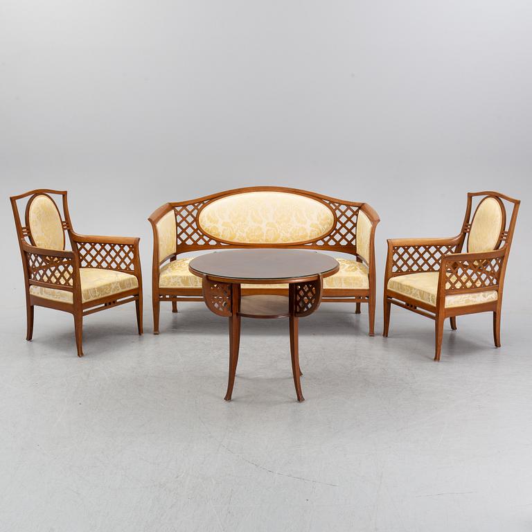 A mahogany sofa, with two armchairs and a round table, early 20th Century.
