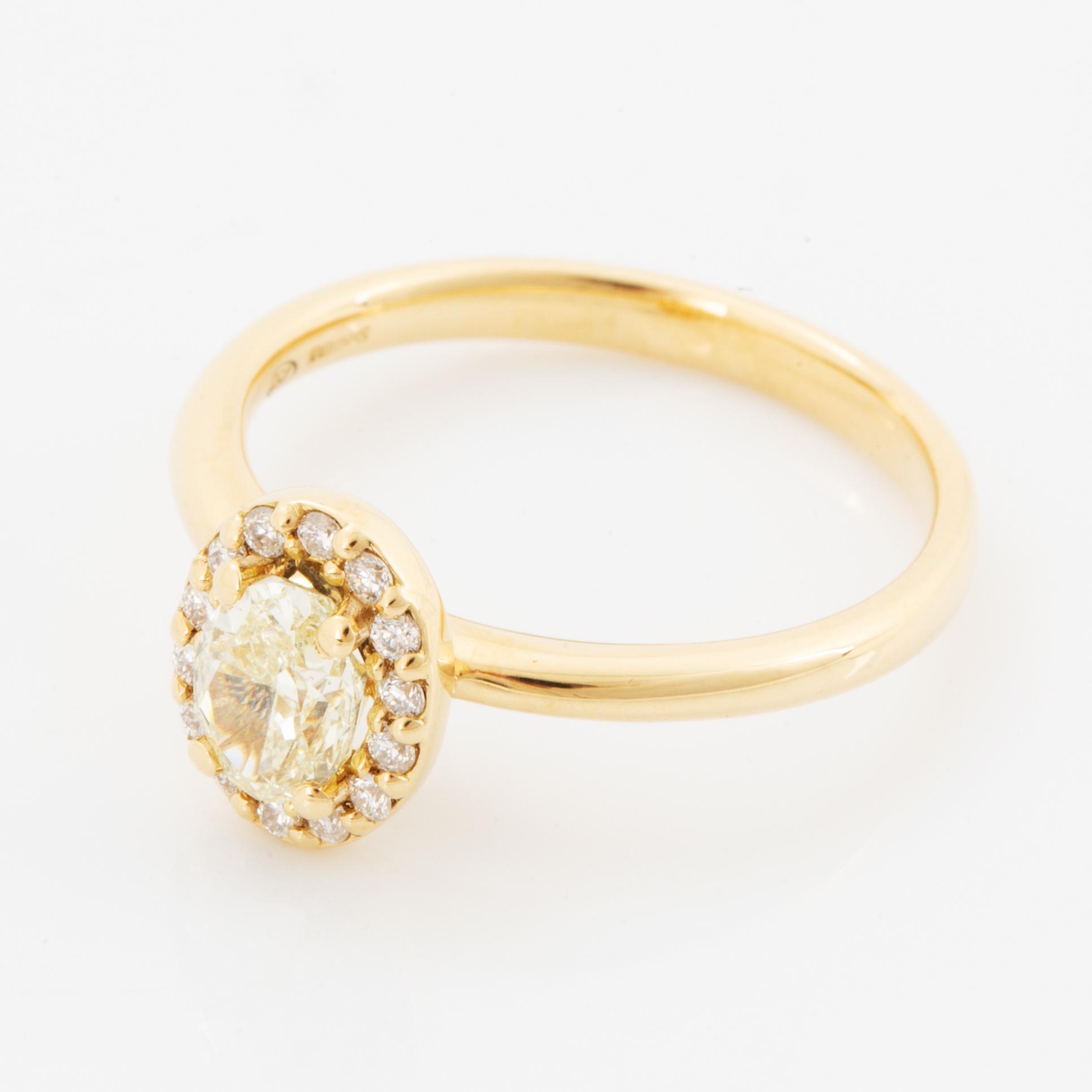 Oval light yellow diamond and brilliant-cut diamond ring.