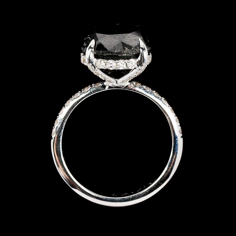 RING, svart briljantslipad diamant, 6.40 ct samt små vita briljantslipade diamanter, tot. 0.40 ct.