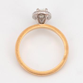 An 18k gold ring set with an oval brilliant-cut diamond.