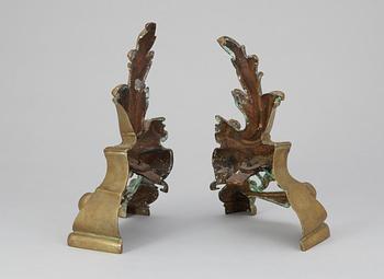 A pair of brass fire dogs. Rococo style.