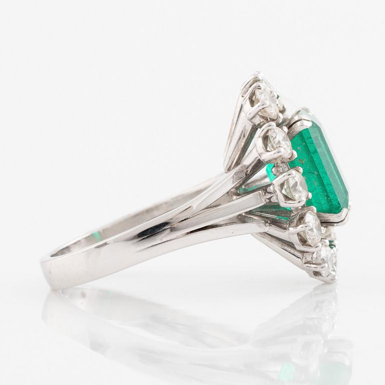 An emerald and round brilliant cut diamond ring.