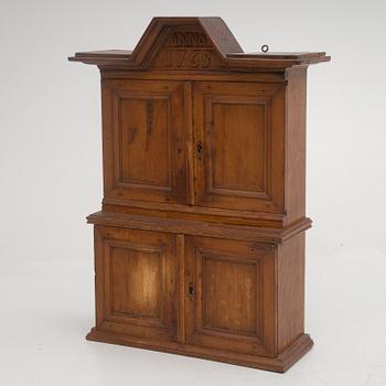 A wall cabinet, dated 1765.