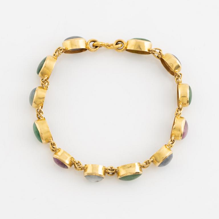 An 18K gold bracelet set with cabochon-cut emeralds and corundum.