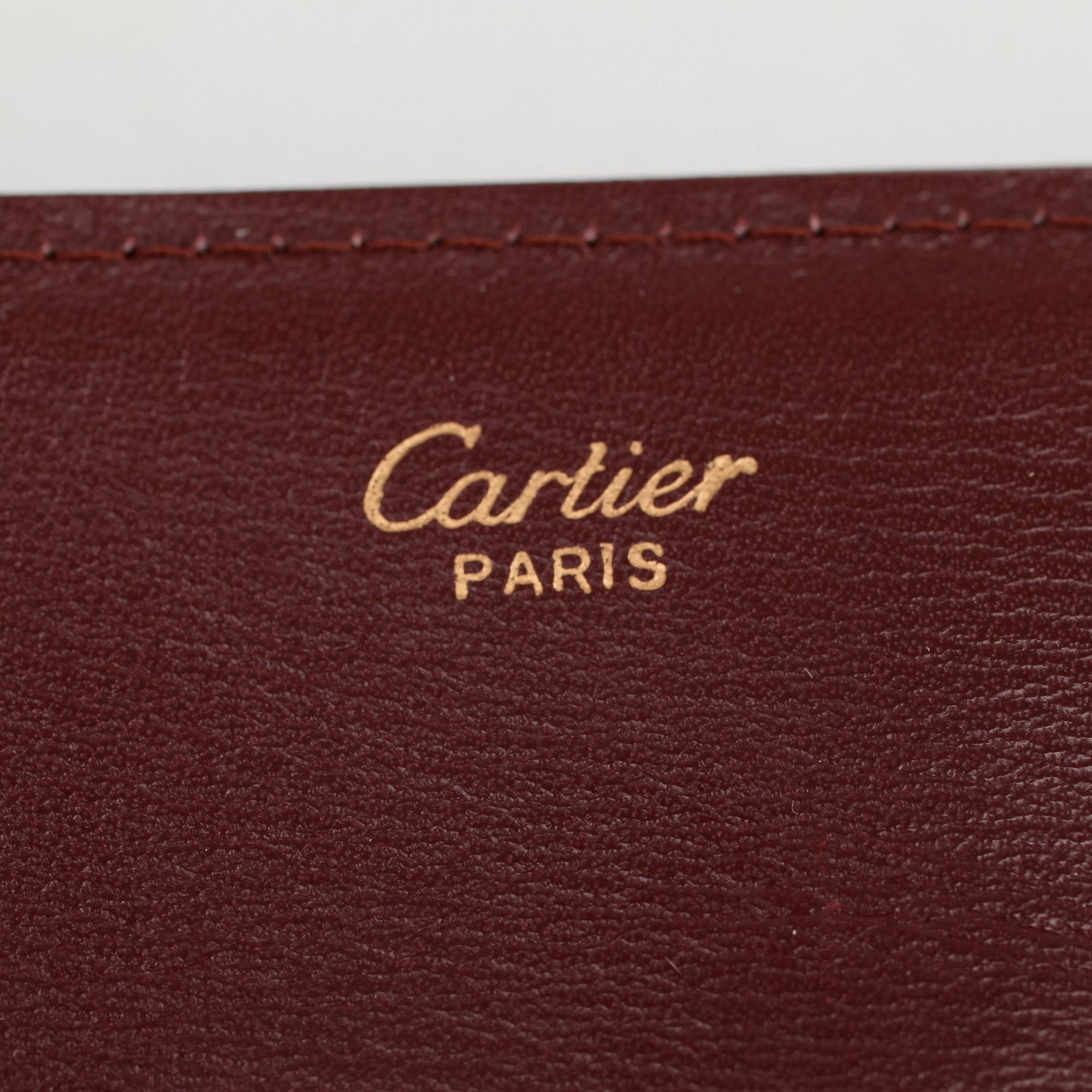 CARTIER, a red leather clutch or travel wallet.
