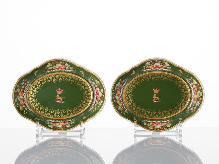 A pair of armorial butter tureens with covers and stands and two fruit dishes, Derby, England, circa 1830.